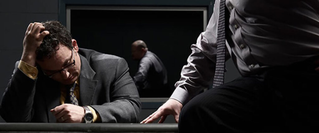 man looking stressed while being interrogated